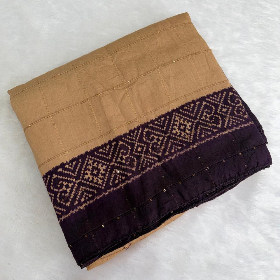 A folded piece of traditional Japanese fabric, likely a yukata or kimono robe, featuring a tan body with a wide dark purple border decorated with geometric patterns and small metallic pins.